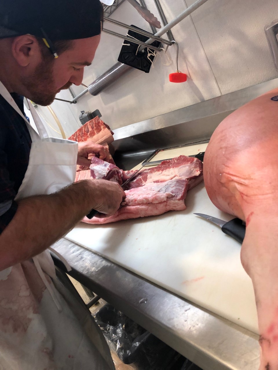 SFM butcher breaking down pork