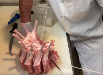 Butcher demonstrates how to make crown roast of pork