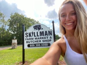 Stacie Faille with our new sign at the end of our driveway at Skillman Farm Market and Butcher Shop